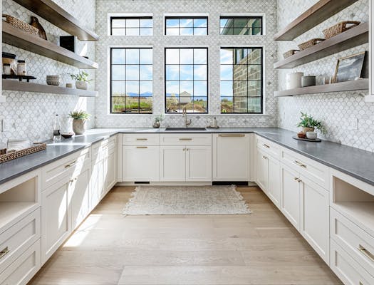 Remodeled kitchen with LVP flooring and a tile backsplash.