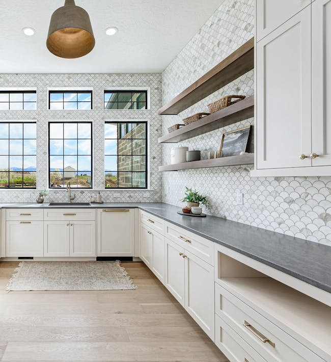 Remodeled kitchen with LVP flooring and a tile backsplash.